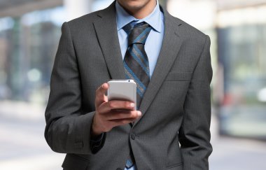 İş adamı cep telefonunu kullanıyor.