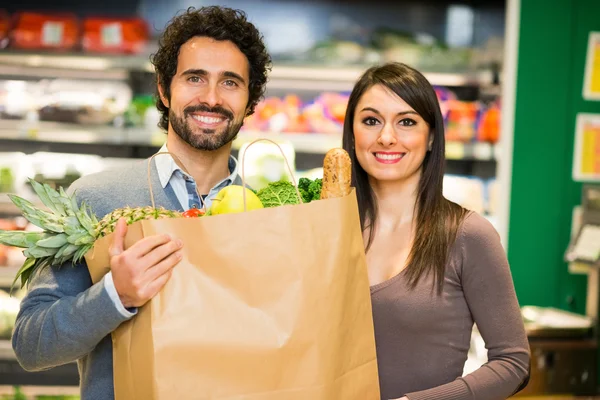 Pareja sosteniendo una bolsa de compras — Foto de Stock