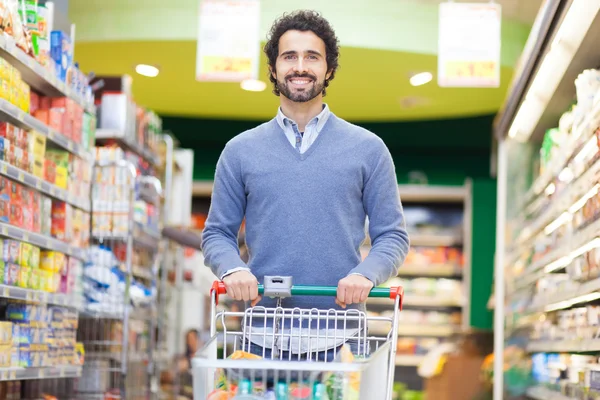 Mann kauft im Supermarkt ein — Stockfoto