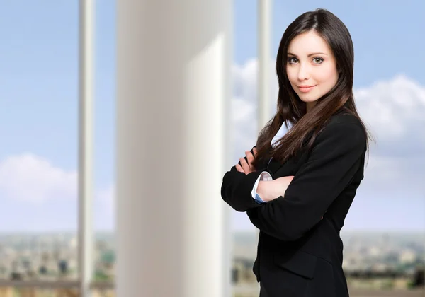 Affärskvinna med armar korsade i office — Stockfoto