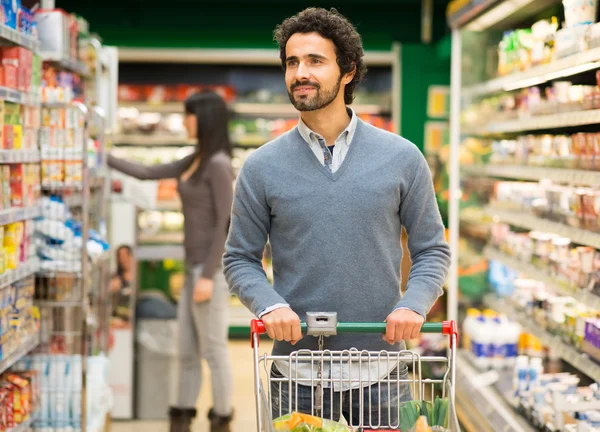Человек делает покупки в супермаркете — стоковое фото