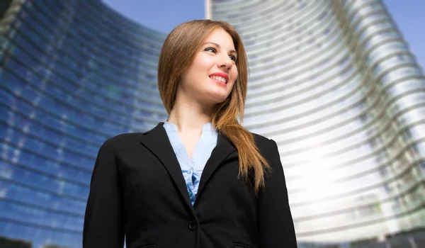 Femme d'affaires souriante devant le gratte-ciel — Photo