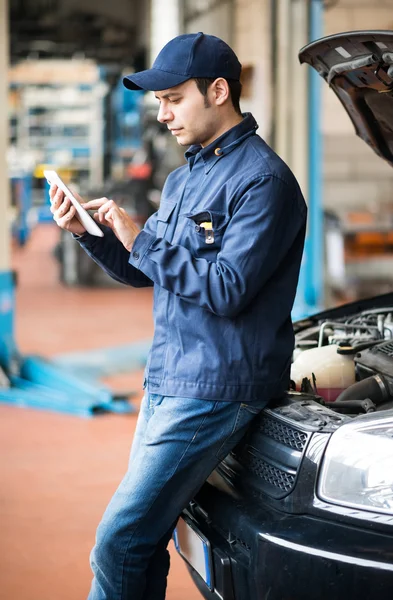 Mechanic using a tablet in garage — Stock Photo, Image