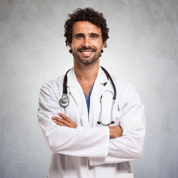 Medico sorridente con le braccia incrociate — Foto Stock