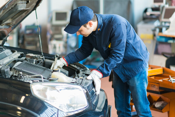 Mechanic at work on car in garage