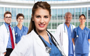 Smiling doctor in front of medical workers clipart