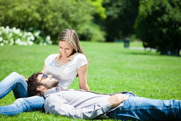 Couple sitting in a park — Stock Photo, Image