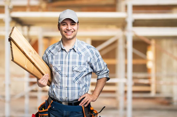 Carpenter holding wood planks — Stock Photo, Image