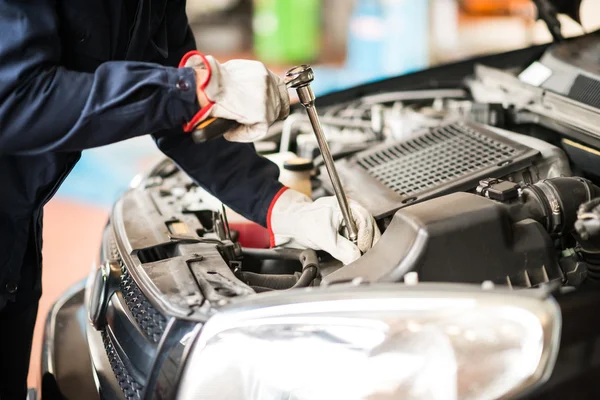 Auto mechanic at work on car in garage — Stock Photo, Image