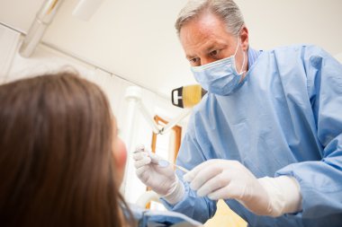 Woman receiving dental treatment clipart