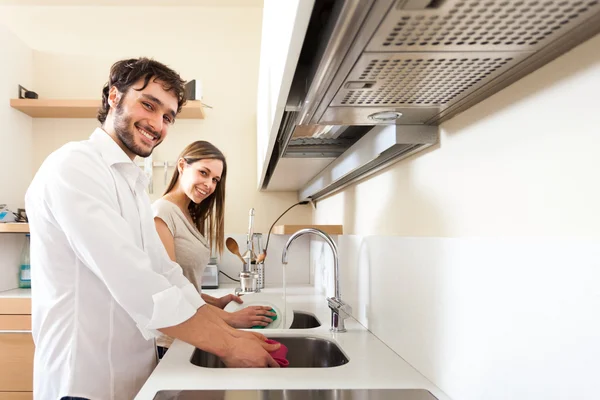 Pareja joven lavando platos — Foto de Stock