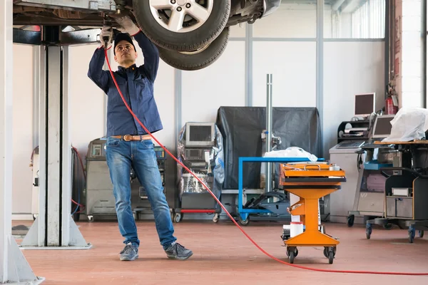 Meccanico al lavoro nel suo garage — Foto Stock