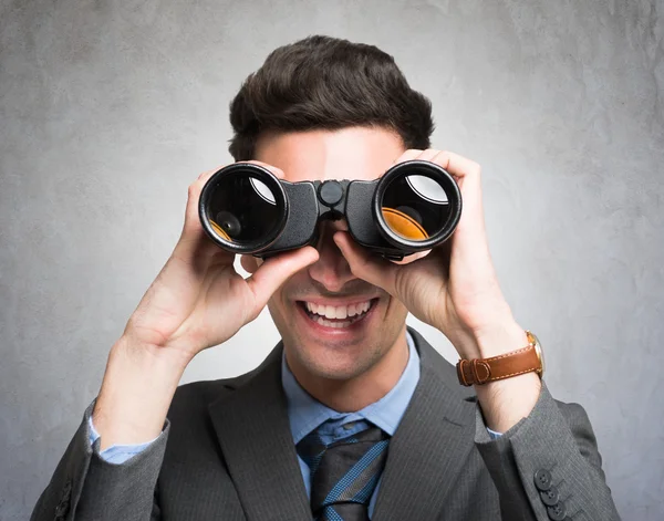 Businessman watching through binoculars — Stock Photo, Image