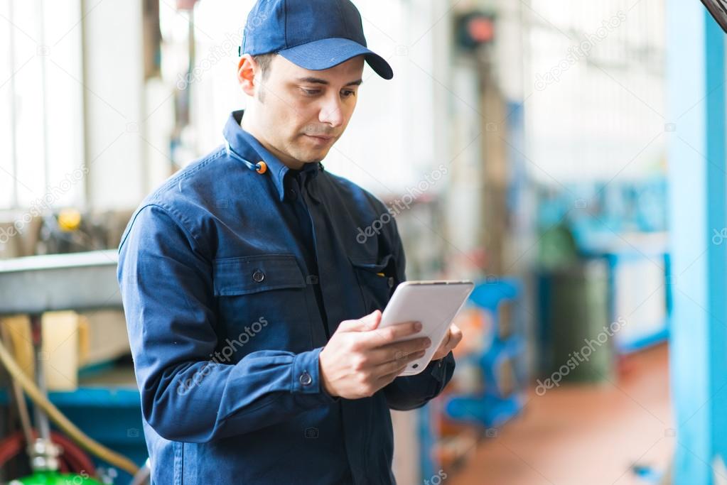 Mechanic using tablet in garage