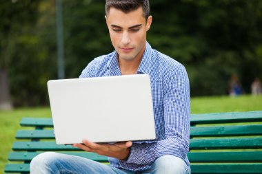 Gülümseyen adam dizüstü bilgisayar kullanıyor