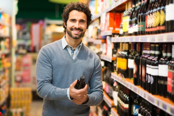 Homme choisissant une bouteille de vin — Photo