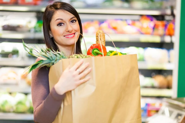 Frau kauft im Supermarkt ein — Stockfoto