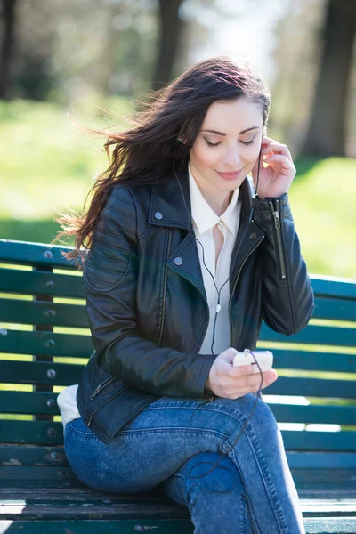 Femme écoute de la musique dans le parc — Photo