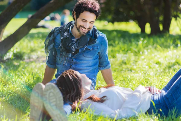 Happy couple sitting in park — Stock Photo, Image