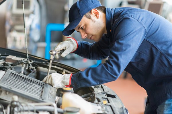 Auto mechanic at work on car