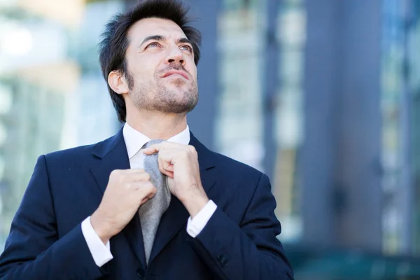 Confident businessman adjusting necktie — Stock Photo, Image