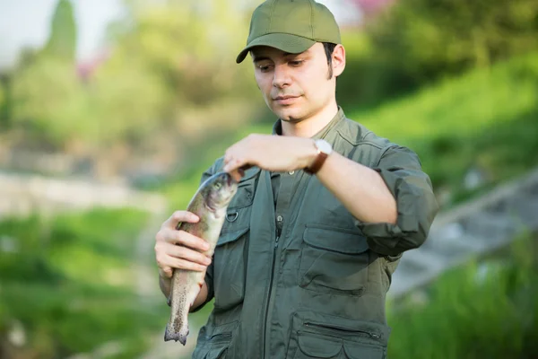 Pescador segurando um peixe — Fotografia de Stock