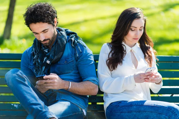 Jong koppel met behulp van smartphones — Stockfoto