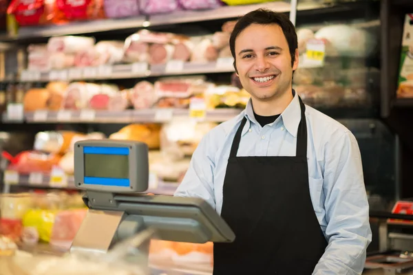 Lachende winkelier in een supermarkt — Stockfoto