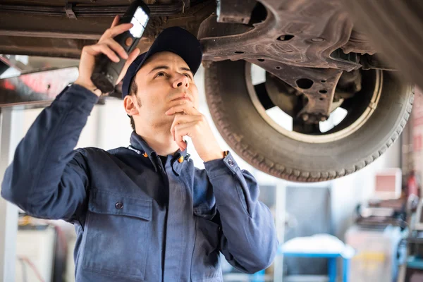 Mechanic inspecting car — Stock Photo, Image