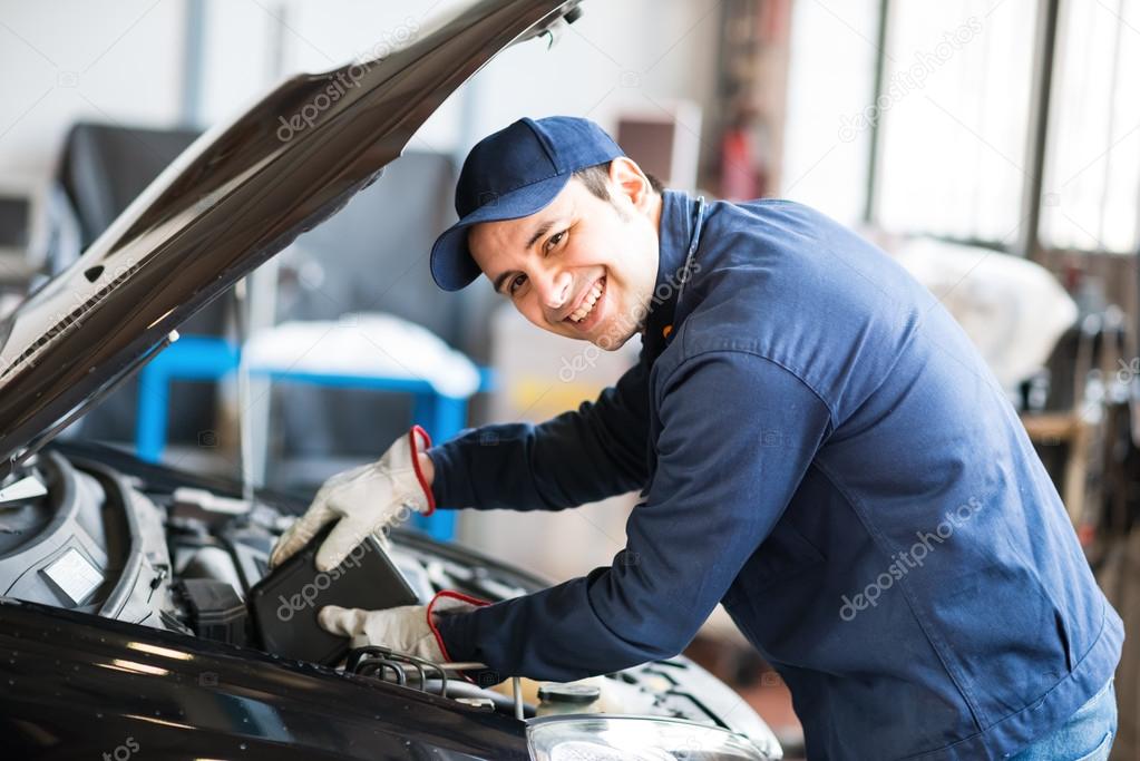 Auto mechanic putting oil in car