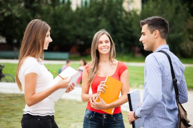 Üç öğrenci bir parkta konuşuyor