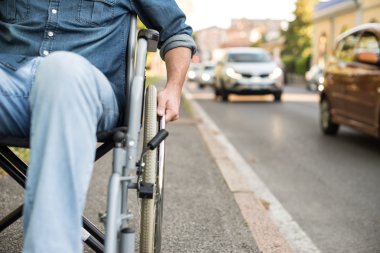 Kentsel bir sokakta bir tekerlekli sandalye kullanan adam