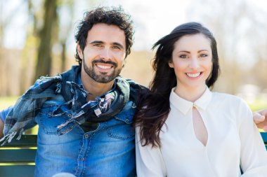 Birbirine aşık çiftler parkta bankta oturuyor.