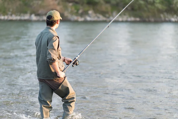 Рыбак рыбачит в реке — стоковое фото