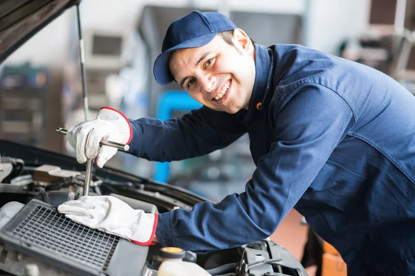 Sorrindo consertar um motor de carro — Fotografia de Stock