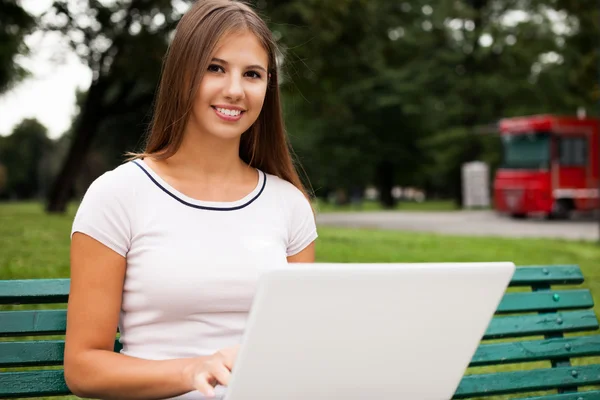 Femme utilisant un ordinateur portable dans un parc — Photo