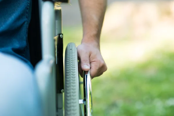 Main sur le volant d'un fauteuil roulant — Photo