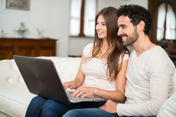 Casal usando um computador portátil — Fotografia de Stock