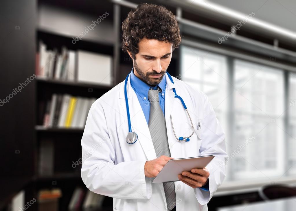 Handsome doctor using tablet
