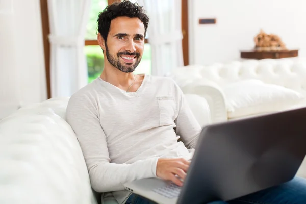 Man using laptop on couch — Stock Photo, Image