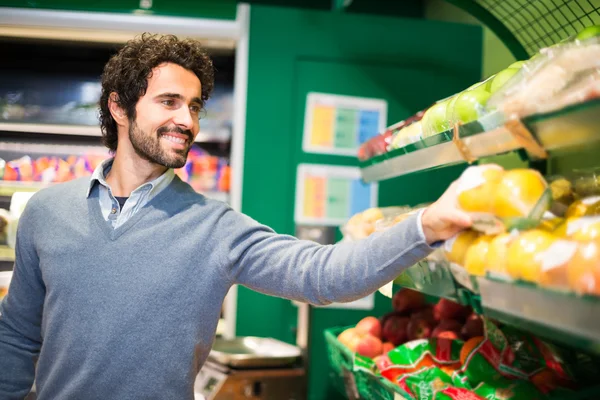 Homme ramassant des légumes en magasin — Photo