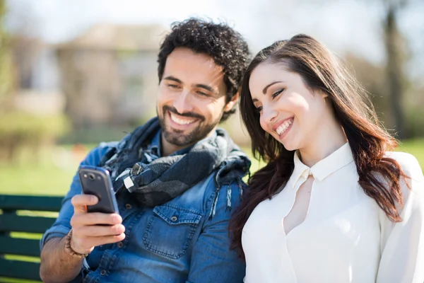 Uomo che mostra il telefono cellulare ad un amico — Foto Stock