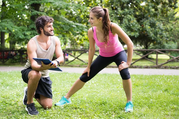 Hombre mostrando programa de entrenamiento a la mujer —  Fotos de Stock