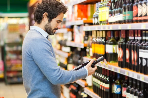 Homem escolhendo garrafa de vinho — Fotografia de Stock