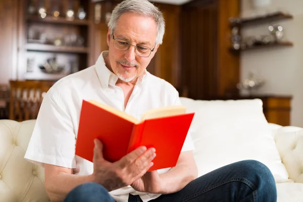 Gammal man läser en bok — Stockfoto