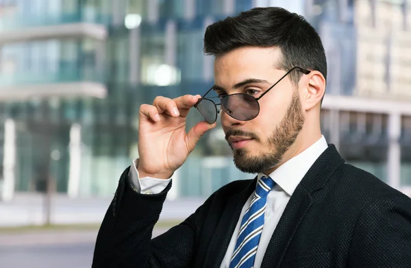 Hombre de negocios sosteniendo sus gafas de sol —  Fotos de Stock