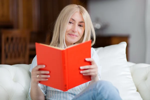 Gammal kvinna läser en bok — Stockfoto