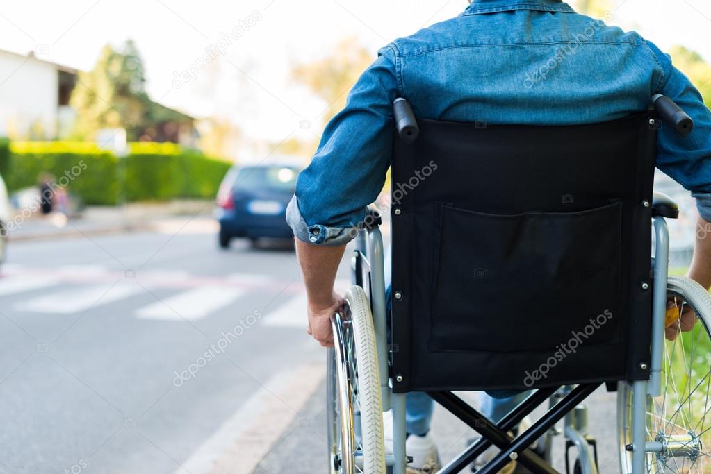 Man in wheelchair preparing to go across road