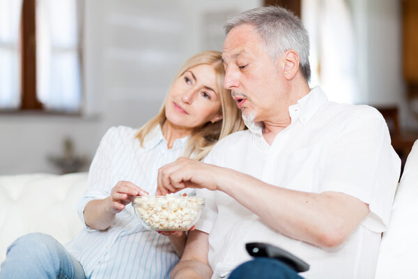 couple eating popcorn while watching movie