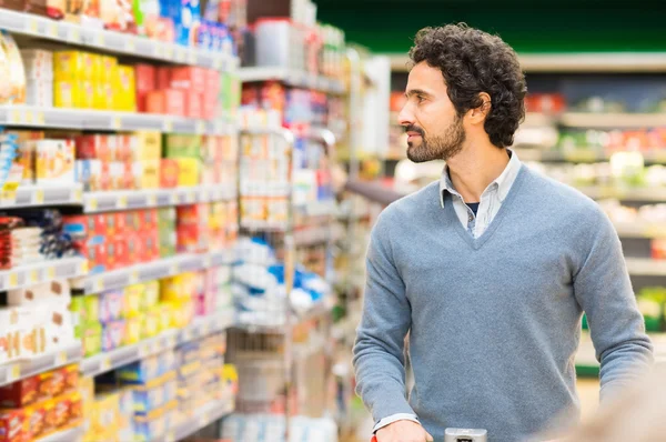 Человек выбирает продукт в супермаркете — стоковое фото